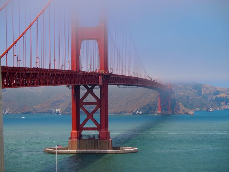 San Francisco's Golden Gate Bridge sparkles, with fog rolling in over top